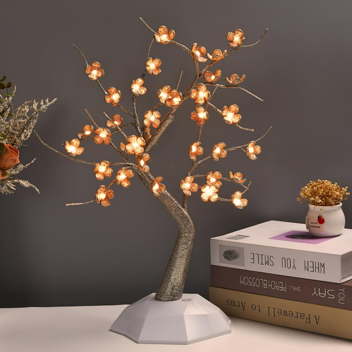 Albero Ciliegio LED acceso su una mensola, fiori traslucidi con luce calda